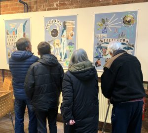 A group of people looking at exhibition poster