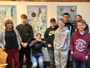 A group of young people in front of a collage poster